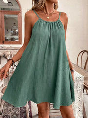 Turquoise spaghetti strap mini dress with gathered neckline and textured fabric.