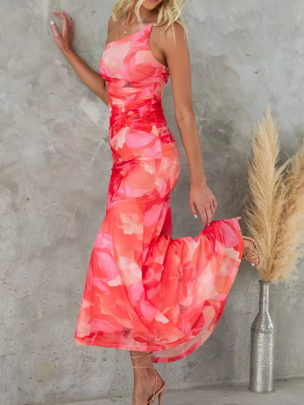One-shoulder maxi dress in red floral print with ruched detailing and asymmetrical neckline.