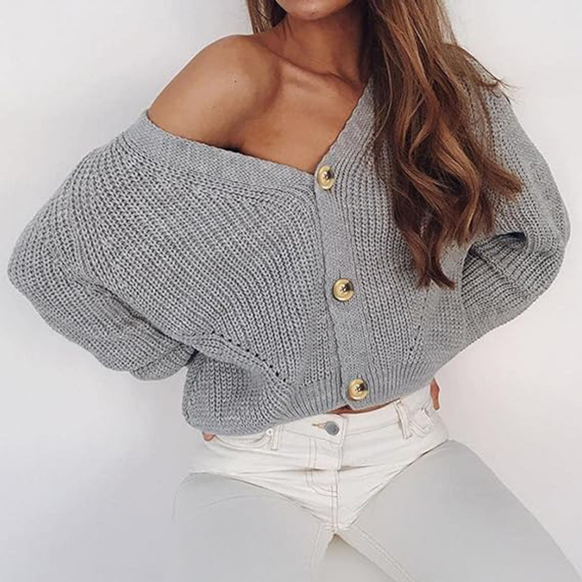 Gray ribbed knit cardigan with balloon sleeves and gold buttons, worn off-shoulder.