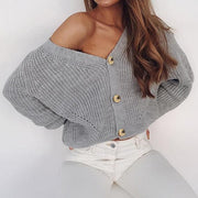 Gray ribbed knit cardigan with balloon sleeves and gold buttons, worn off-shoulder.