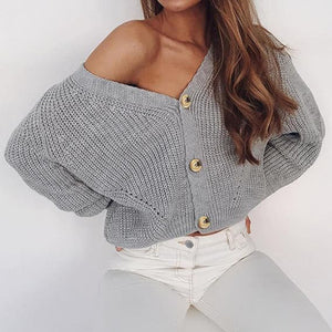 Gray ribbed knit cardigan with balloon sleeves and gold buttons, worn off-shoulder.