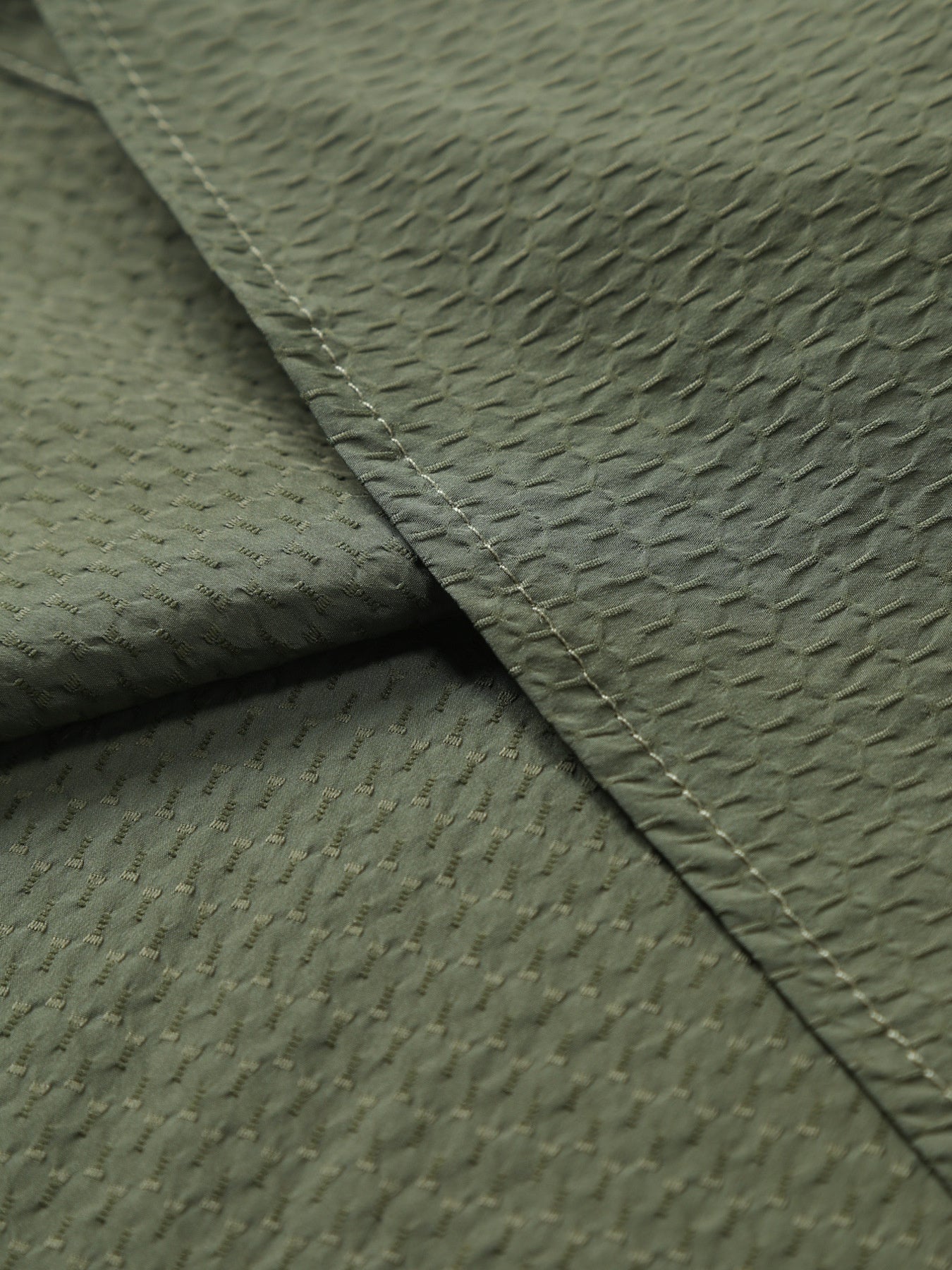 Army green cotton casual shirt with textured pattern and visible stitching.