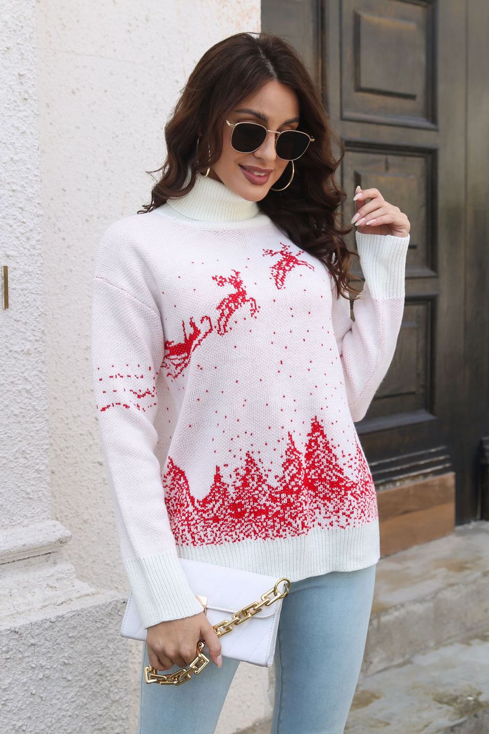 White acrylic turtleneck sweater with red reindeer and forest pattern.