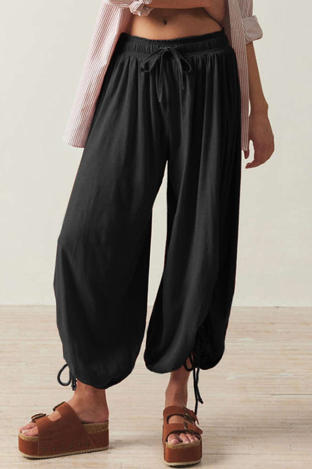 Black balloon trousers with gathered ankle ties and drawstring waist