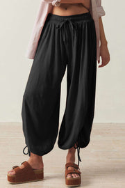 Black balloon trousers with gathered ankle ties and drawstring waist