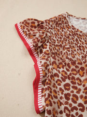 Smocked leopard print blouse with ruffled cap sleeves and red striped trim.