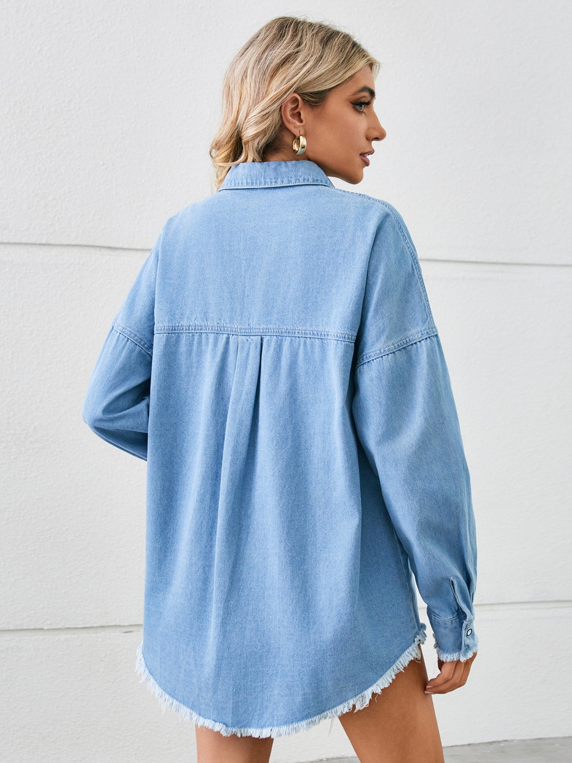 Light blue oversized denim overshirt with distressed hem and pleat detail on back.