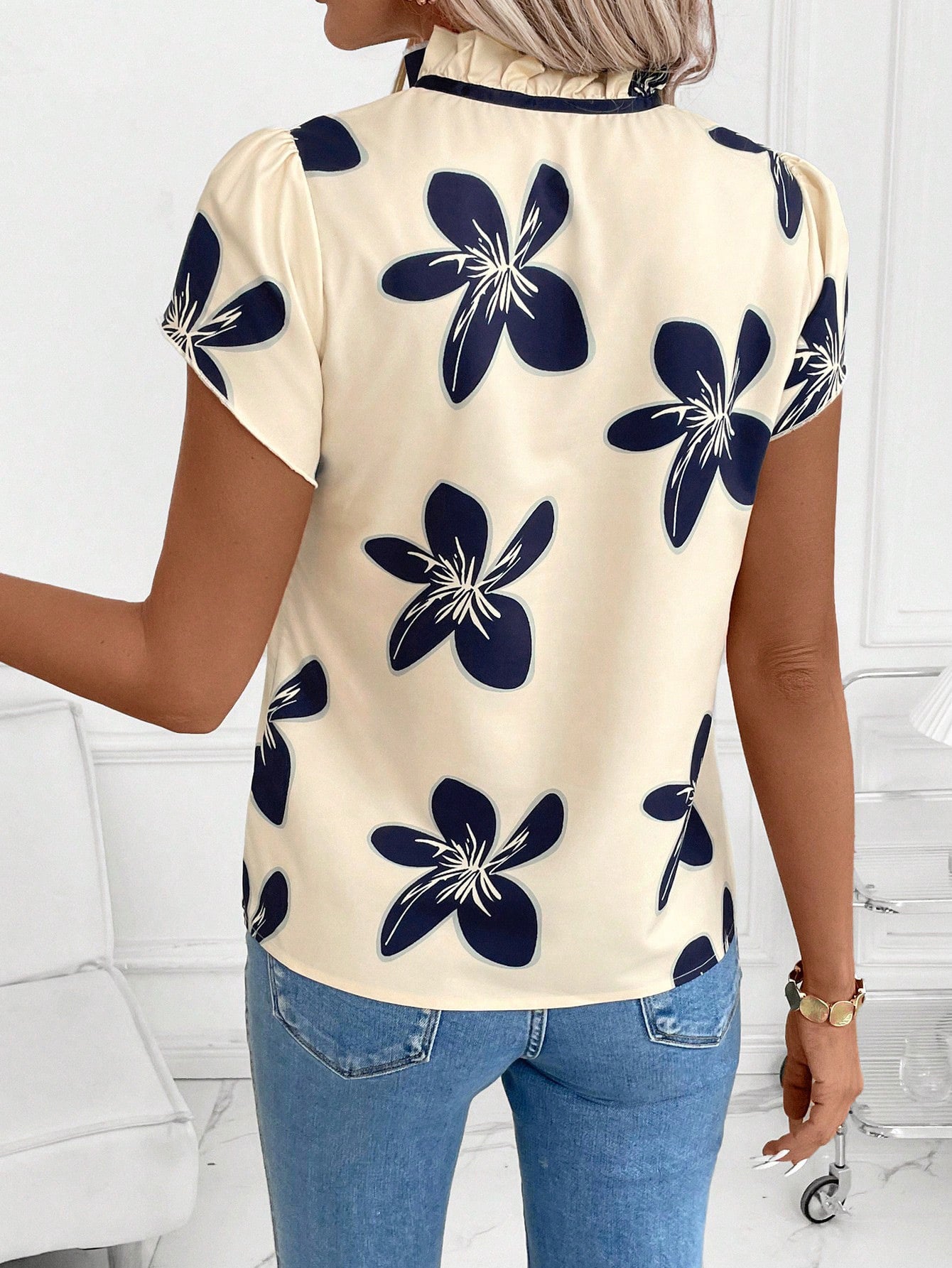 Apricot floral print blouse with ruffled tie-neck and puff sleeves.