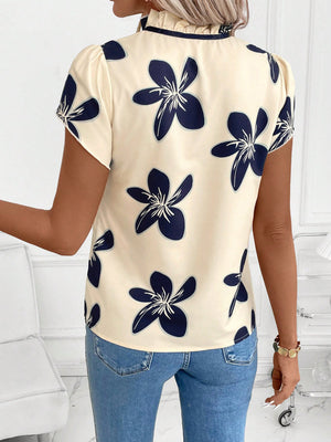 Apricot floral print blouse with ruffled tie-neck and puff sleeves.