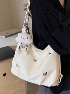 White shoulder bag with butterfly appliques and a cloud charm.