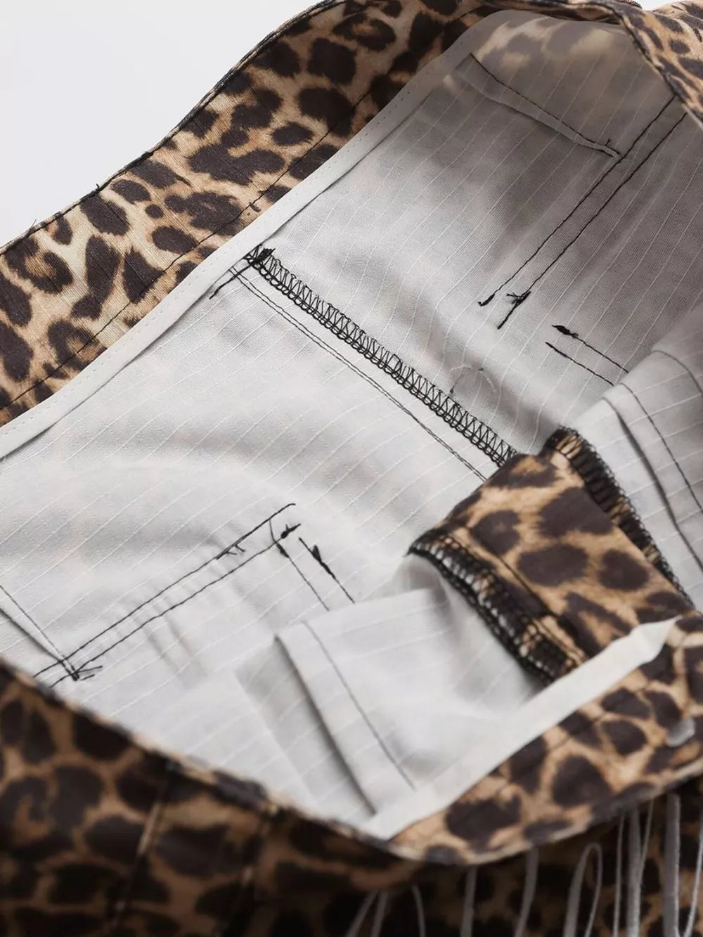 Men's leopard print cargo sweatpants with striped lining and visible stitching detail.