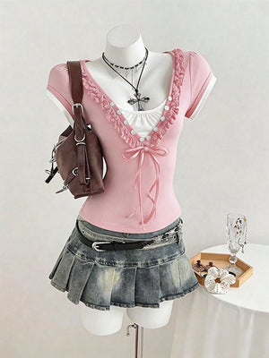 Pink maternity t-shirt with white trim, ruffled neckline, bow detail, and short sleeves.