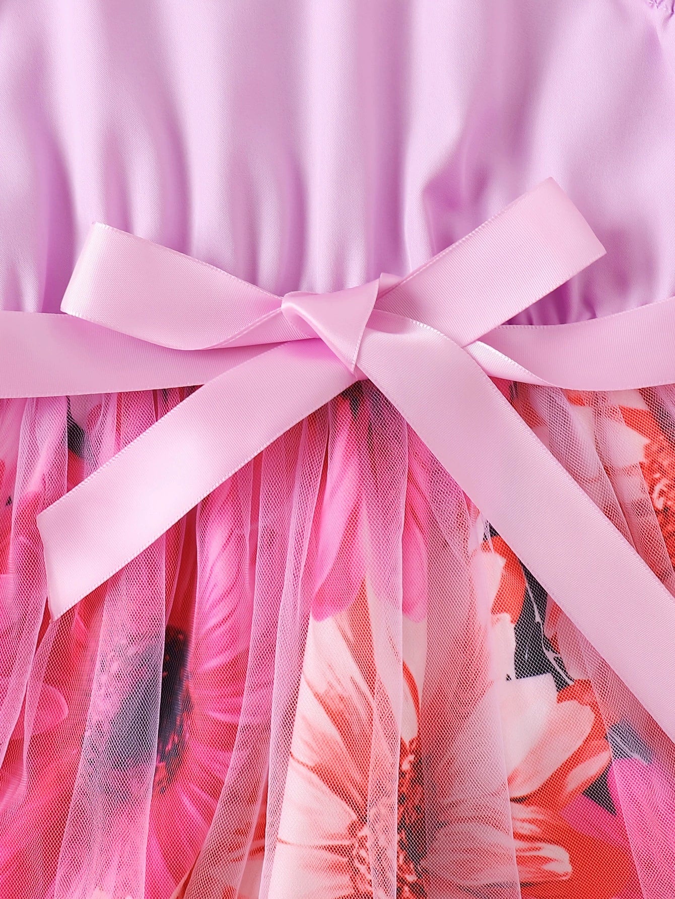 Toddler dress with pink bow detail and floral print skirt overlayed with pink tulle.