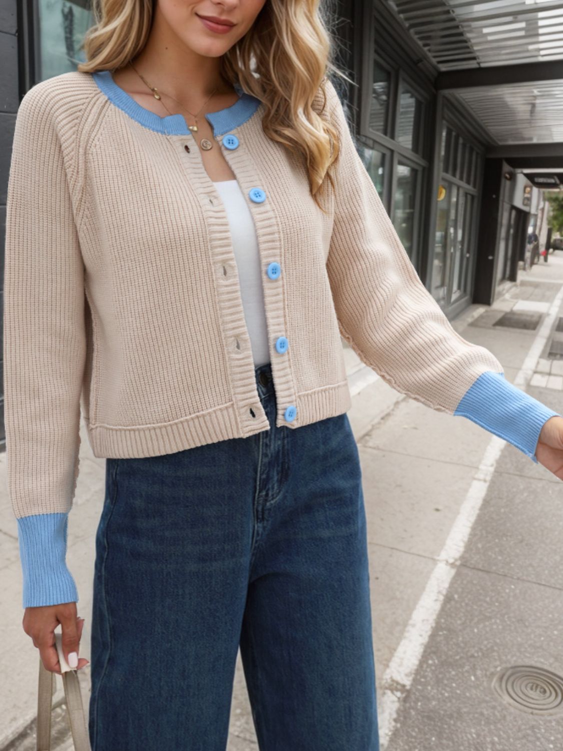 Raglan sleeve colorblock knit cardigan in tan with blue trim and buttons.