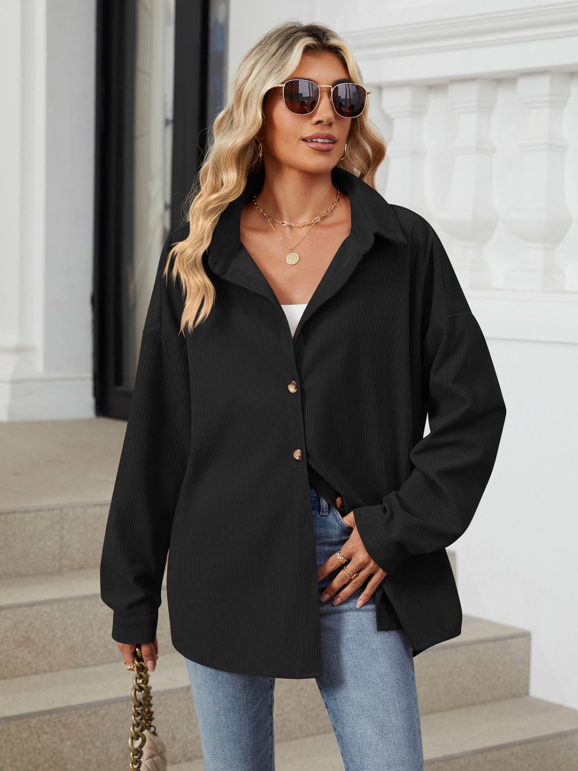 Oversized black corduroy shirt jacket with button front and collar.
