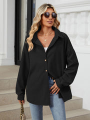 Oversized black corduroy shirt jacket with button front and collar.