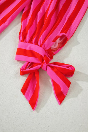 Vibrant puff sleeve shirt with red and pink stripes and a tie detail on the cuff.