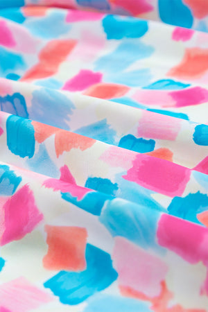 Smocked bodice blouse with brushstroke print in teal, sherbet, and pastel blue.
