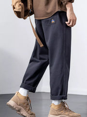 Plus-size dark gray cotton wide-leg trousers with cuffed hems and embroidered back pocket detail.