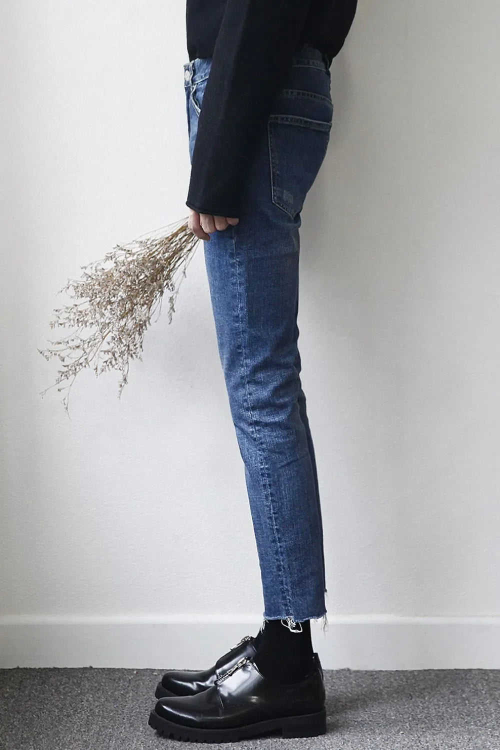 Medium wash slim-fit jeans with raw hem detail