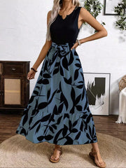 Maxi dress with black leaf print on blue-grey, V-neck, sleeveless, belted waist, tiered hem