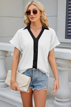 White perforated polo top with black collar and V-neck detail, short sleeves