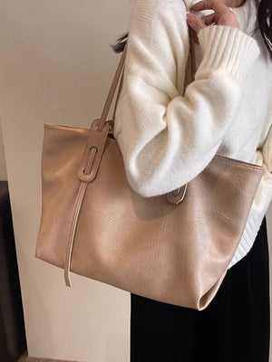 Khaki pu leather shoulder bag with top handle detail and adjustable strap.