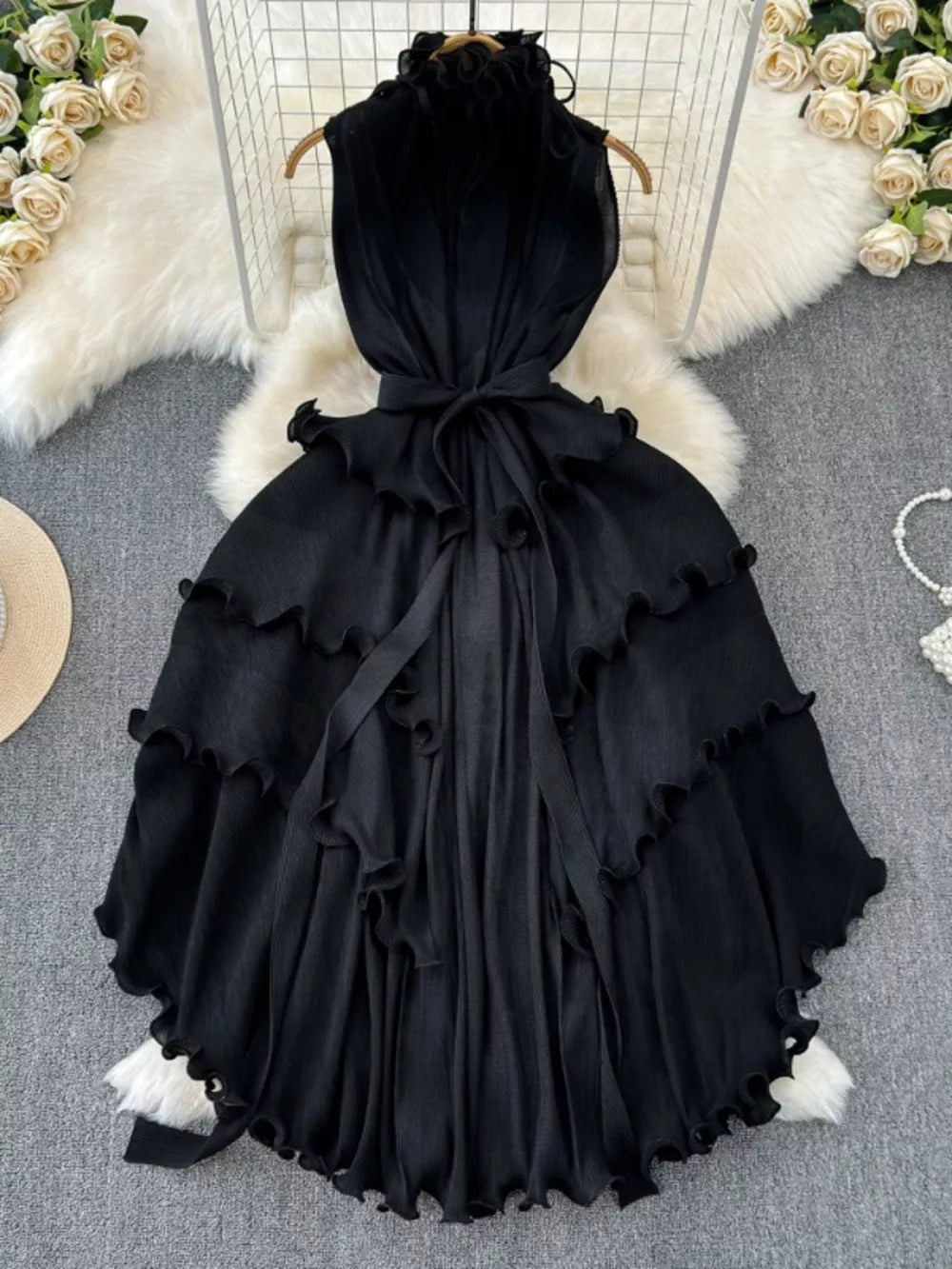 Black ruffled tiered midi dress with belted waist and frill details.