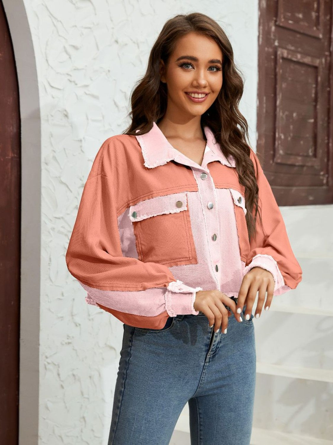 Textured colorblock cropped jacket in pink and coral with raw edges and button pockets.