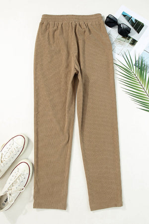 Khaki corduroy drawstring trousers with slant pockets and a relaxed fit.