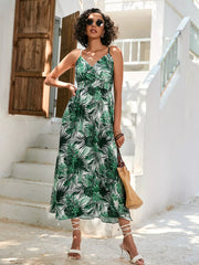 Chic floral midi dress with spaghetti straps in dark green, featuring a tropical leaf print.
