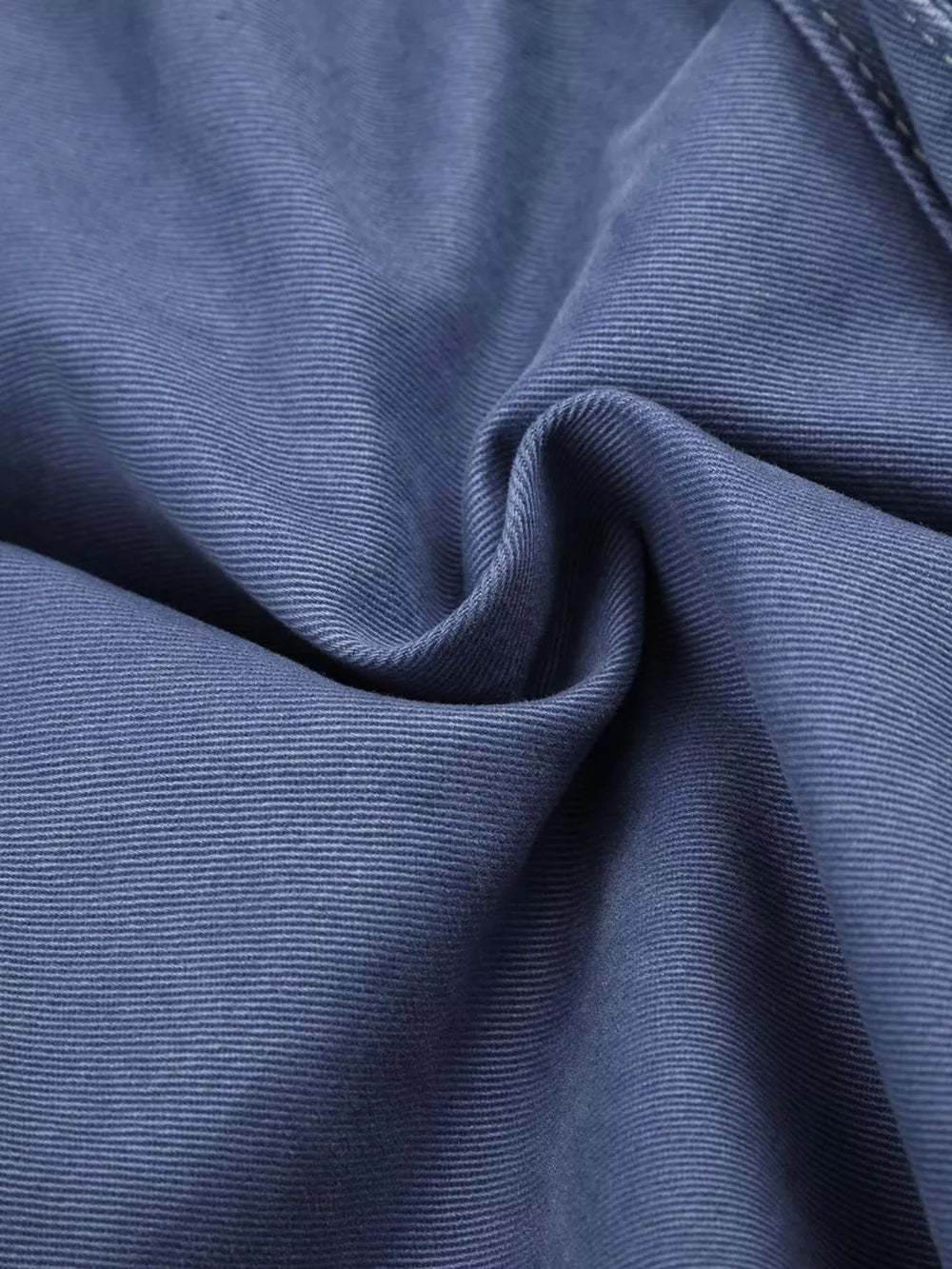 Blue faded cargo capris with distressed detailing and subtle texture.