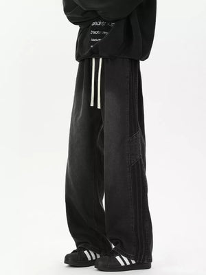 Black relaxed fit wide-leg jeans with drawstring and striped detail.