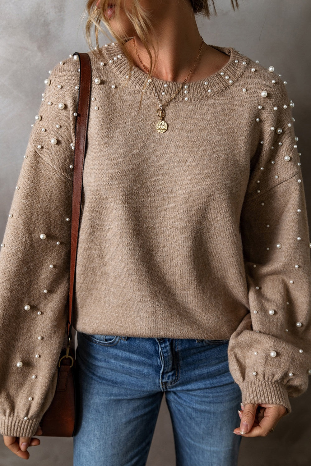 Mocha knit sweater with pearl embellishments on the sleeves and neckline.