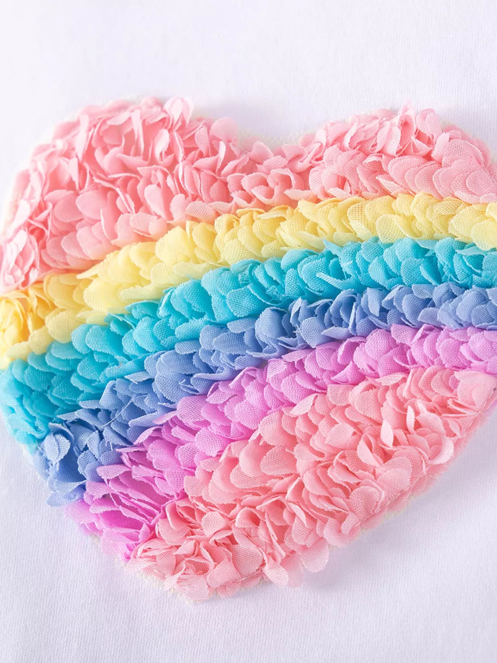Baby dress with rainbow heart applique made of textured fabric petals.