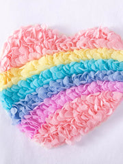 Baby dress with rainbow heart applique made of textured fabric petals.