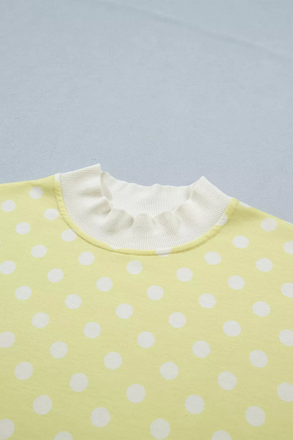 Pastel yellow polka dot top with ruffled neckline detail