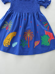 Blue cotton baby dress with smocked bodice, puff sleeves, and jungle animal embroidery.