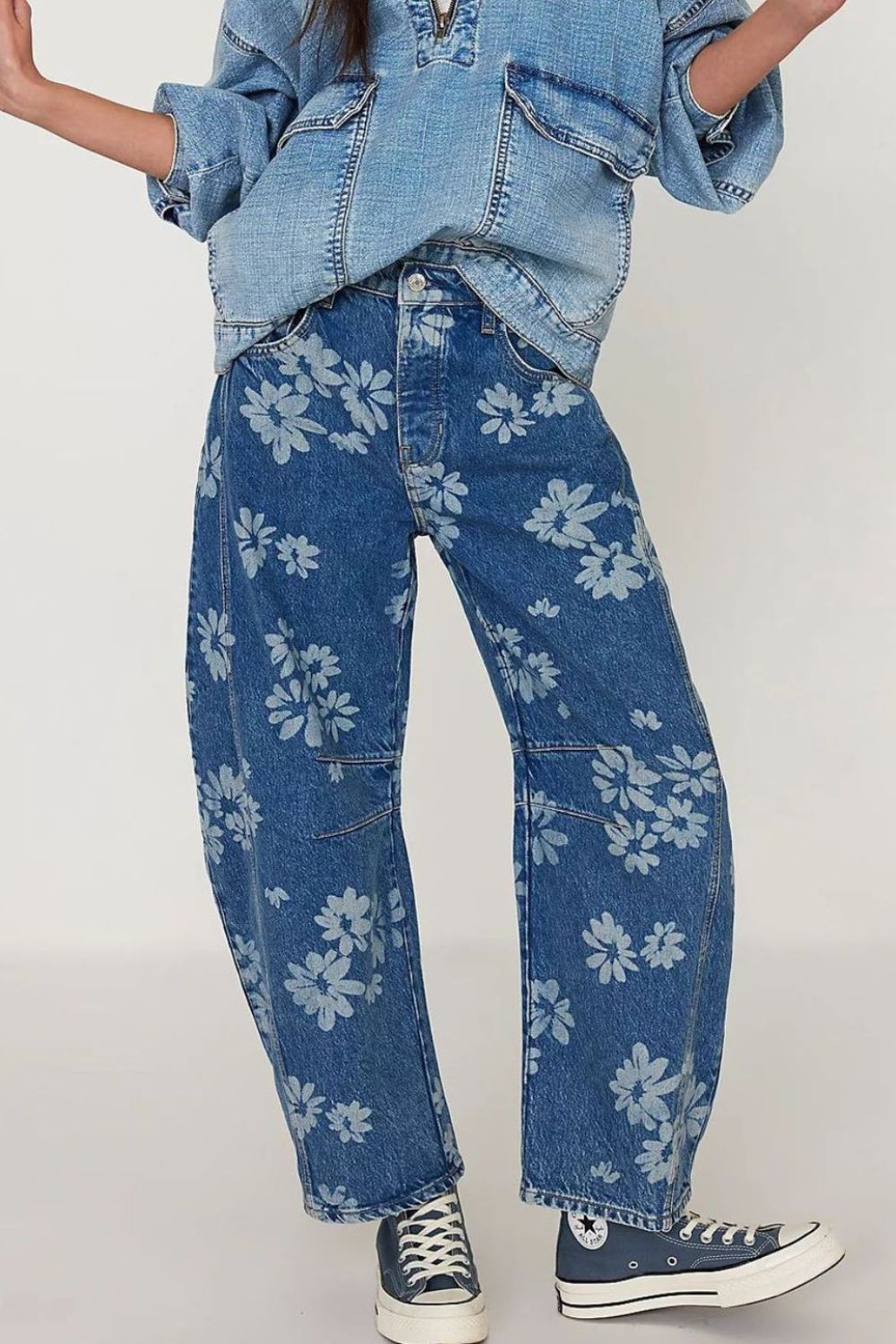 Floral print balloon denim jeans in medium wash with a relaxed fit and all-over daisy pattern.