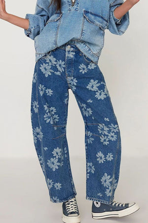 Floral print balloon denim jeans in medium wash with a relaxed fit and all-over daisy pattern.