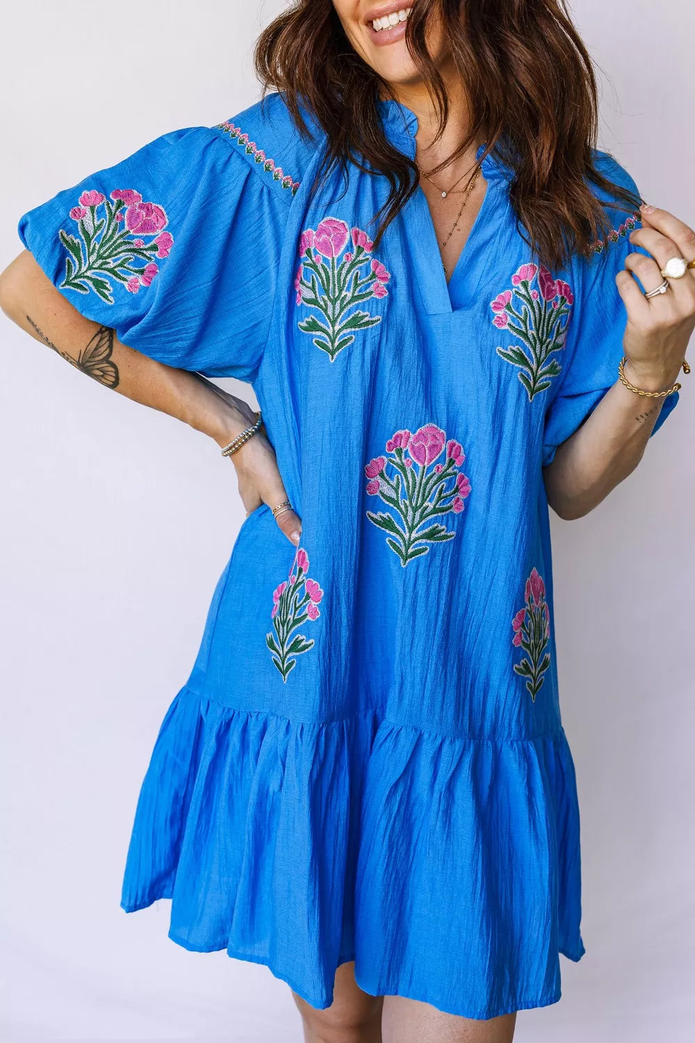 Blue embroidered floral dress with ruffle hem and short sleeves.