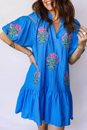 Blue embroidered floral dress with ruffle hem and short sleeves.