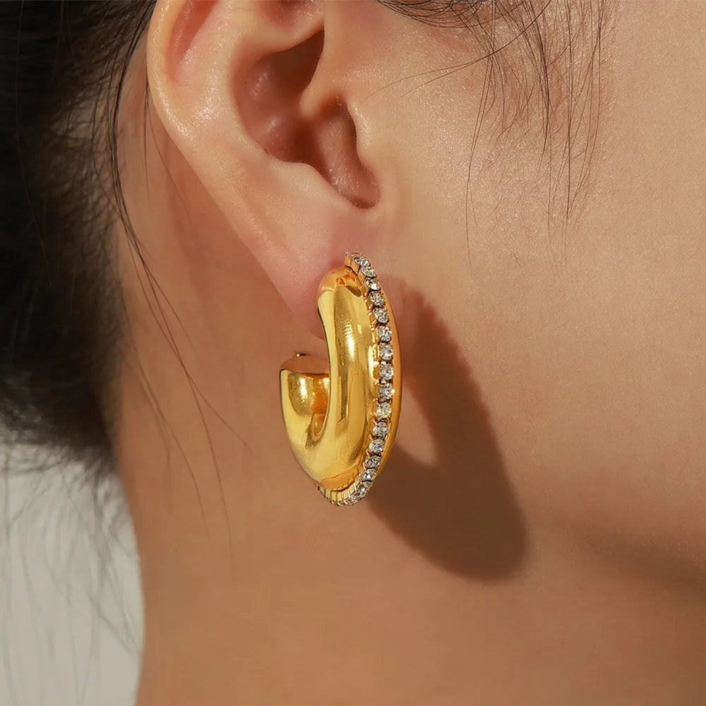 Gold cubic zirconia embellished crescent hoop earrings with a polished finish.