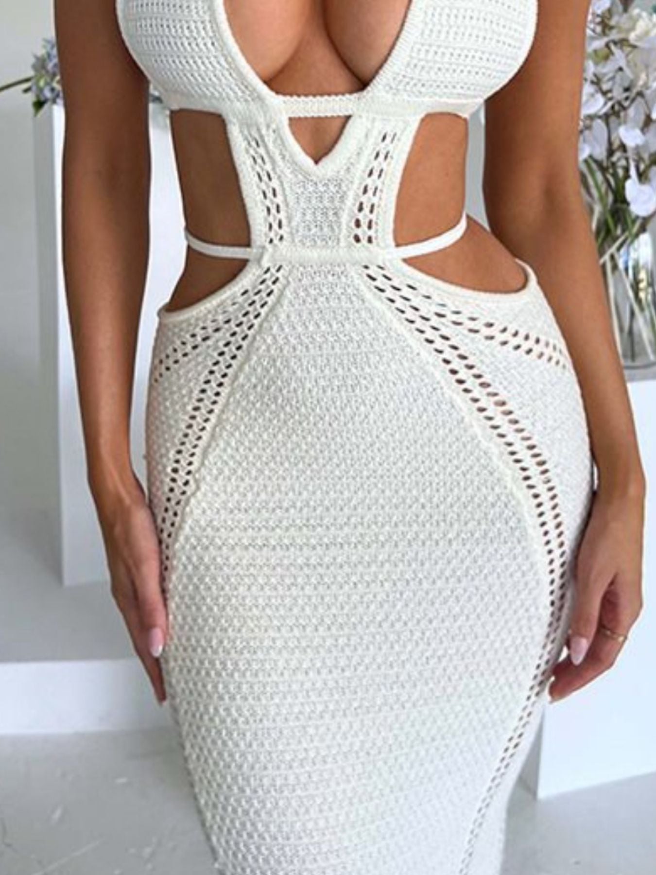 White knitted maxi dress with deep V-neck, cutouts, and backless detail.