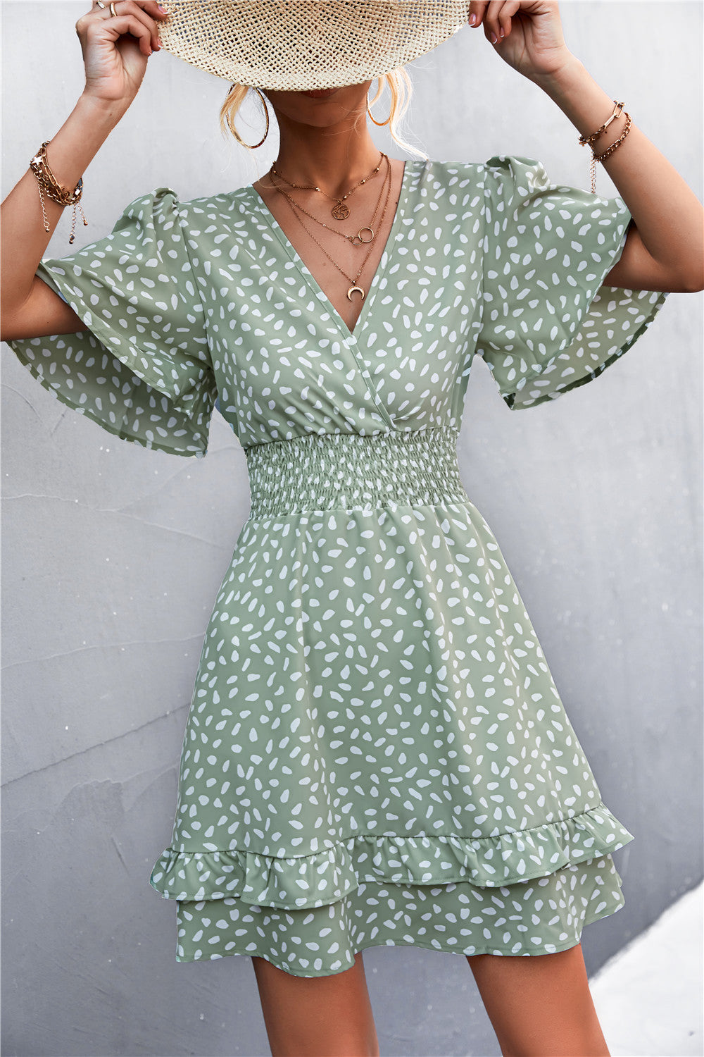 Gum Leaf smocked waist mini dress with flutter sleeves and a ruffled hem.