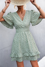Gum Leaf smocked waist mini dress with flutter sleeves and a ruffled hem.