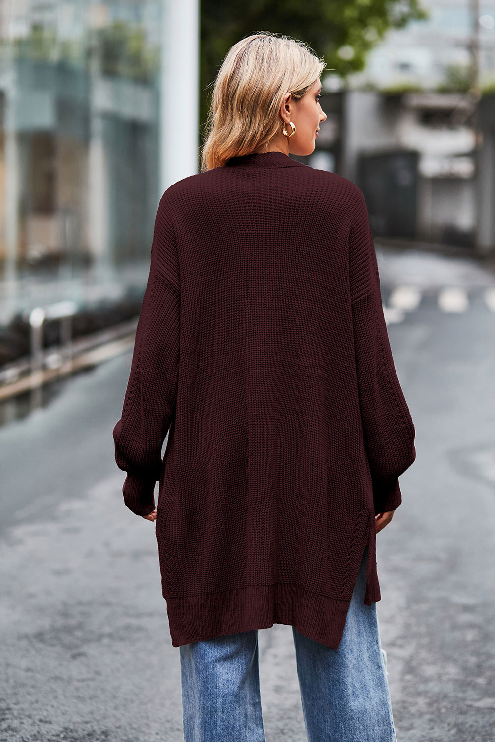 Longline open-knit cardigan in wine with side slits and textured sleeves.