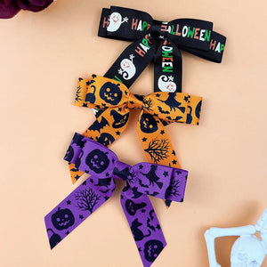 Halloween print bow hair clips in black, tangerine, and violet with spooky patterns.