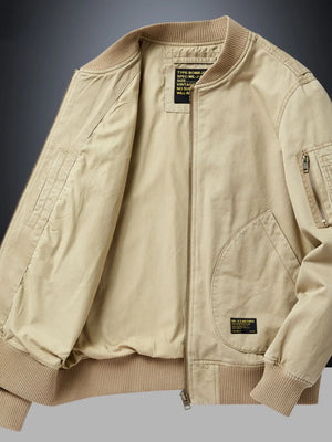 Khaki bomber jacket with patch detail, zip pockets, and ribbed cuffs.