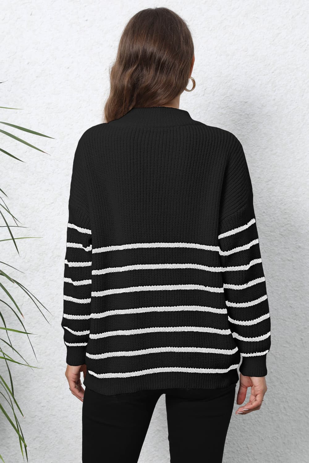 Black and white striped ribbed knit sweater with a quarter-zip neckline.